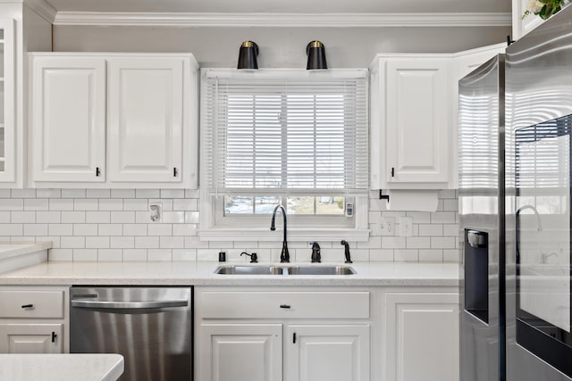 kitchen with stainless steel appliances, sink, white cabinets, and decorative backsplash