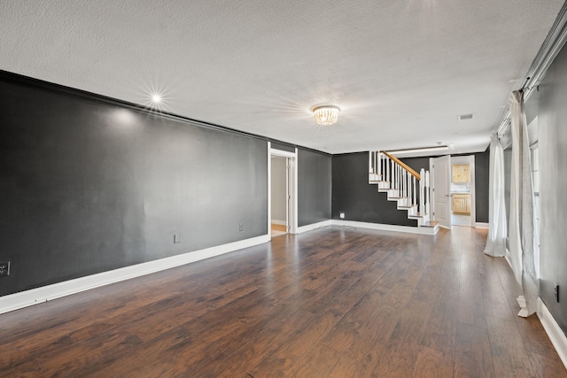 spare room with hardwood / wood-style floors, a barn door, and a textured ceiling