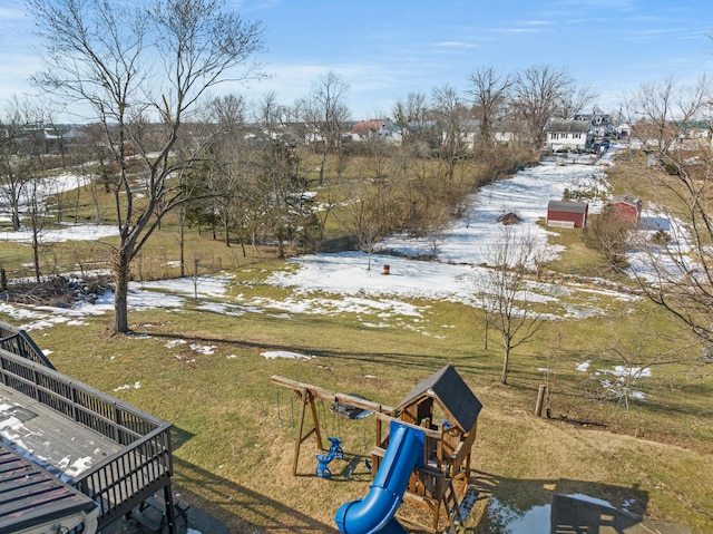 yard covered in snow featuring a playground