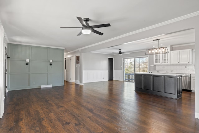 unfurnished living room with ornamental molding, dark hardwood / wood-style floors, and ceiling fan with notable chandelier