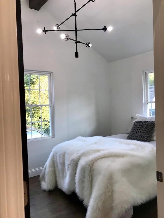 bedroom with vaulted ceiling and wood finished floors