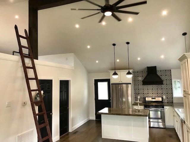 kitchen featuring premium range hood, visible vents, appliances with stainless steel finishes, a center island, and dark wood finished floors