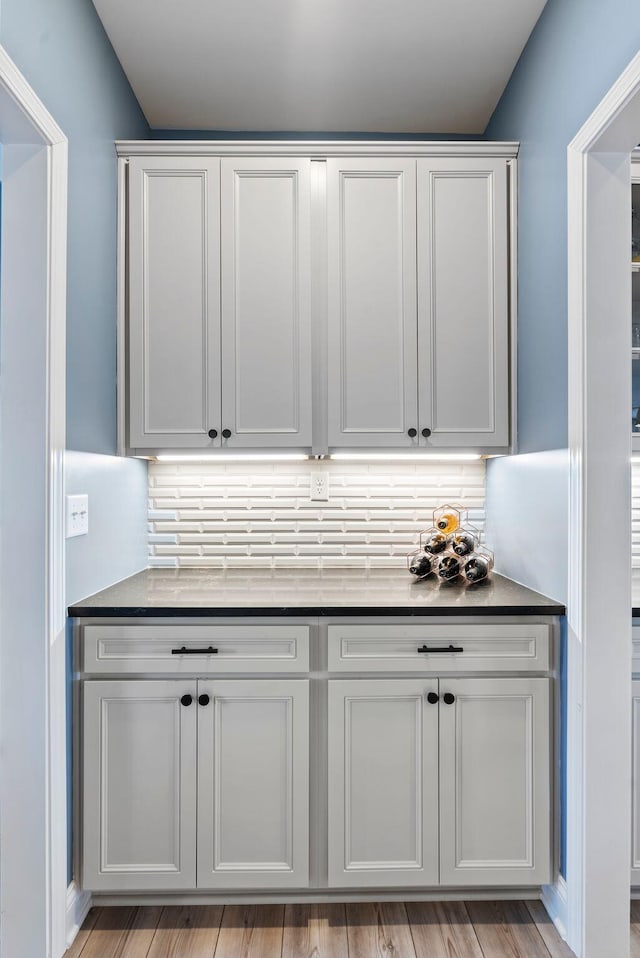 interior space featuring white cabinetry, backsplash, and light hardwood / wood-style flooring