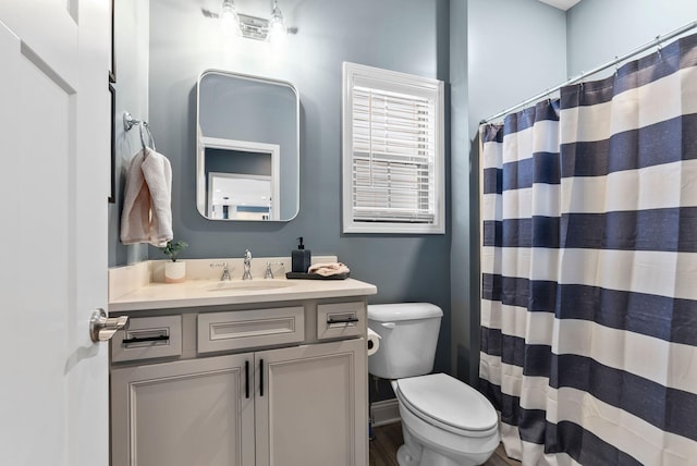 bathroom with vanity, a shower with shower curtain, and toilet