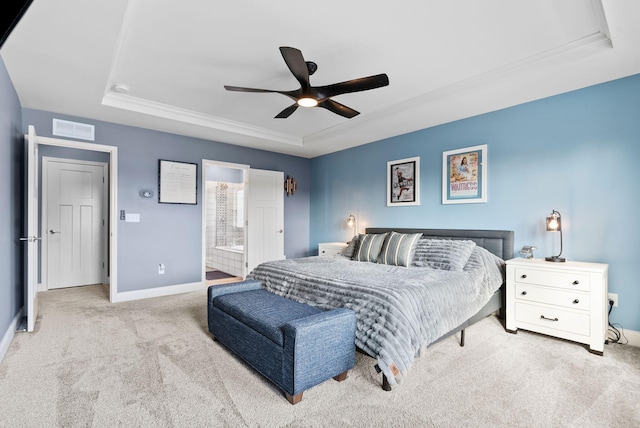 carpeted bedroom featuring connected bathroom, a raised ceiling, and ceiling fan