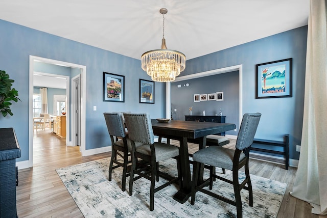 dining room with hardwood / wood-style floors and a notable chandelier