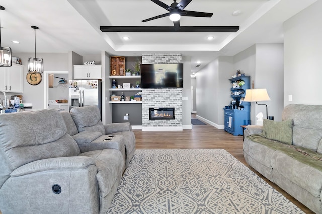 288 Liam Way, Paint Lick, KY 40461 - living area with wood finished floors, a ceiling fan, a fireplace, baseboards, and a raised ceiling
