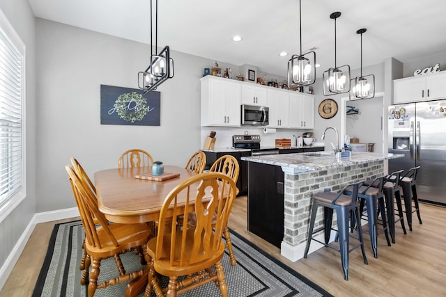 288 Liam Way, Paint Lick, KY 40461 - kitchen with a sink, a kitchen island with sink, an inviting chandelier, light wood-style flooring, and appliances with stainless steel finishes