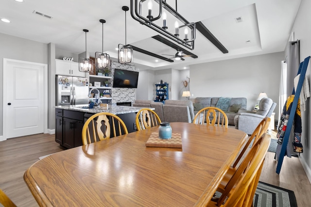 288 Liam Way, Paint Lick, KY 40461 - dining area featuring a raised ceiling, ceiling fan with notable chandelier, visible vents, and wood finished floors