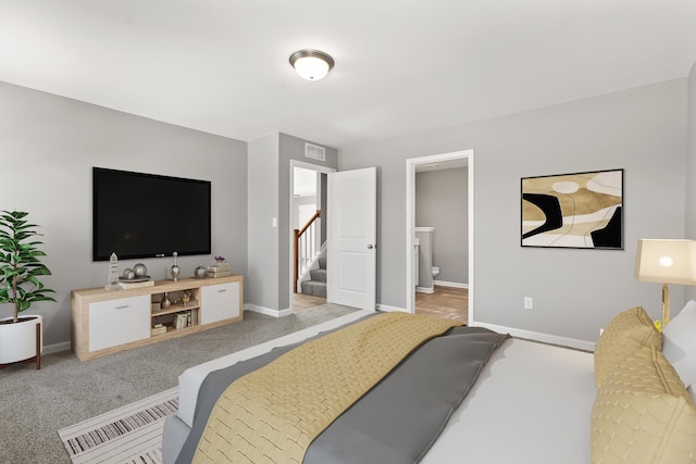 carpeted bedroom featuring ensuite bath