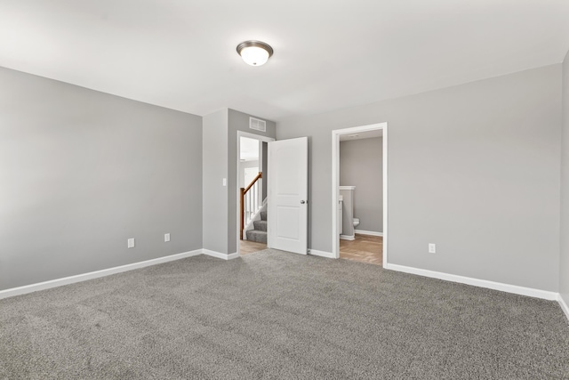 unfurnished bedroom with a walk in closet, connected bathroom, and carpet floors