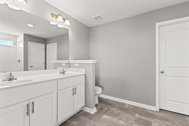 bathroom with vanity, toilet, and a shower