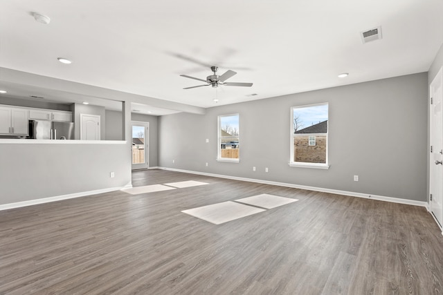 unfurnished living room featuring ceiling fan and dark hardwood / wood-style flooring