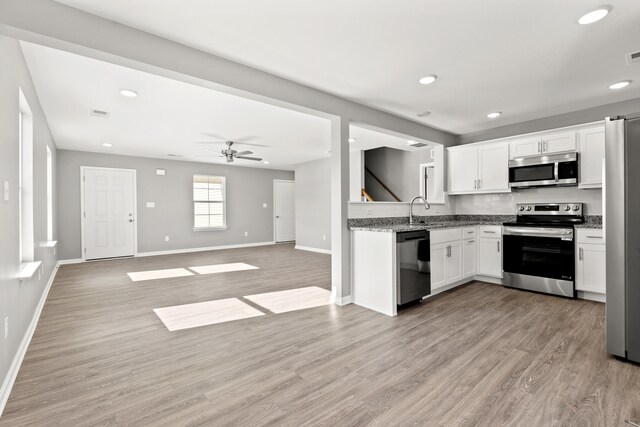 kitchen with white cabinetry, appliances with stainless steel finishes, sink, and light wood-type flooring