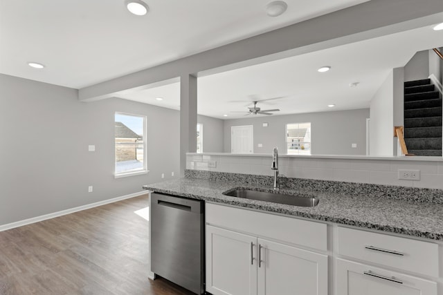 kitchen featuring sink, white cabinetry, light stone counters, tasteful backsplash, and dishwasher