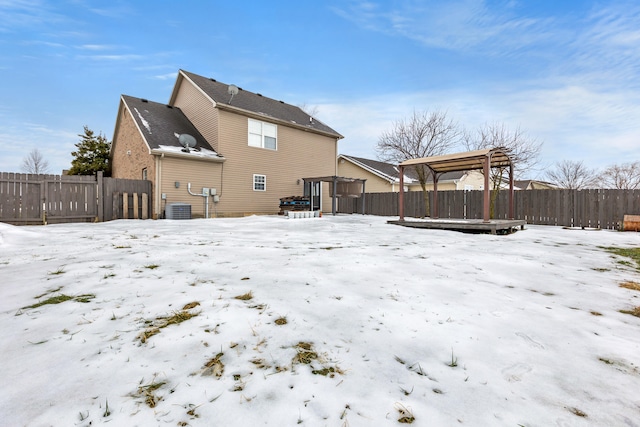 snow covered property with central AC