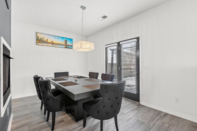 dining room with hardwood / wood-style flooring and an inviting chandelier