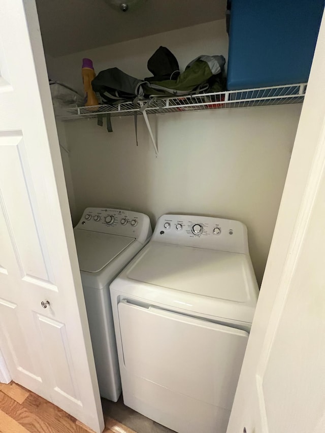 laundry area with light hardwood / wood-style floors and washing machine and dryer