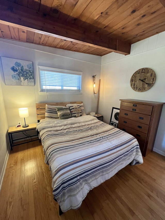 bedroom featuring light wood-type flooring, wooden ceiling, and beam ceiling