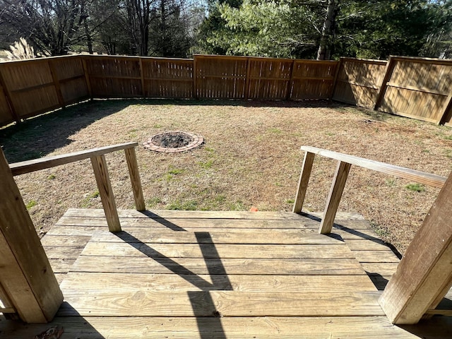 view of yard with a wooden deck and a fire pit