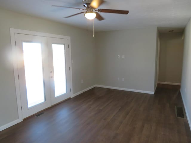 spare room with dark wood-type flooring, ceiling fan, and french doors