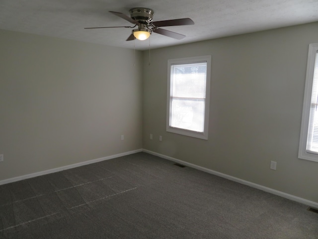 unfurnished room featuring ceiling fan and dark carpet