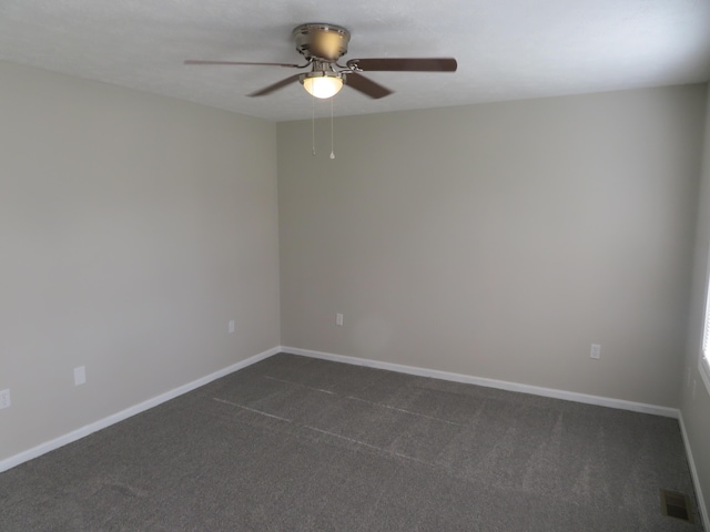 spare room featuring ceiling fan and dark carpet