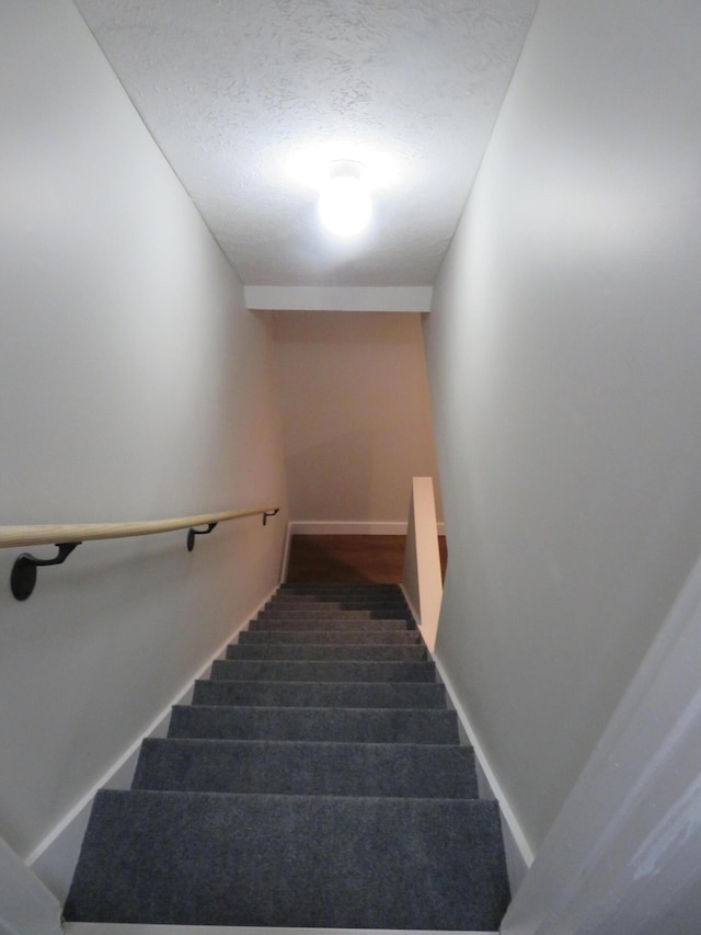 stairway with a textured ceiling