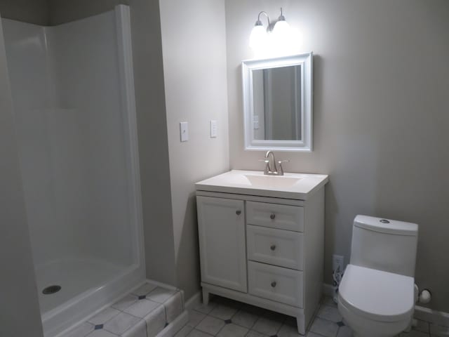 bathroom with vanity, a shower, tile patterned floors, and toilet