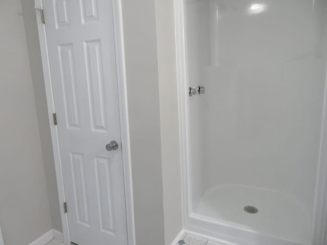 bathroom with tile patterned floors and walk in shower