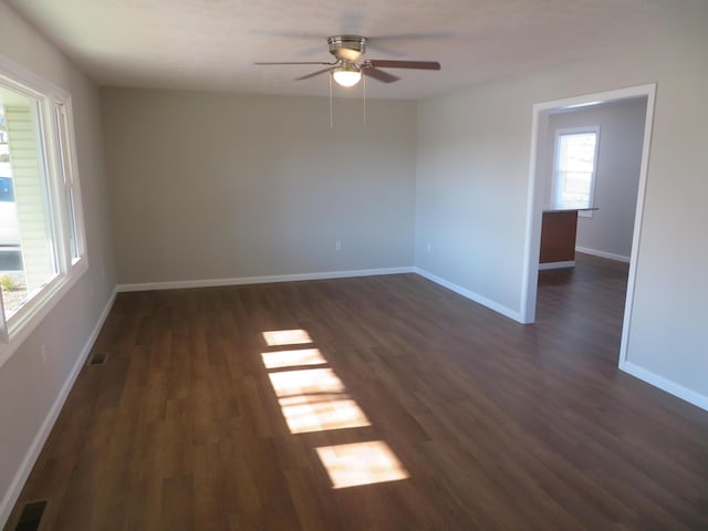 empty room with dark hardwood / wood-style flooring and ceiling fan