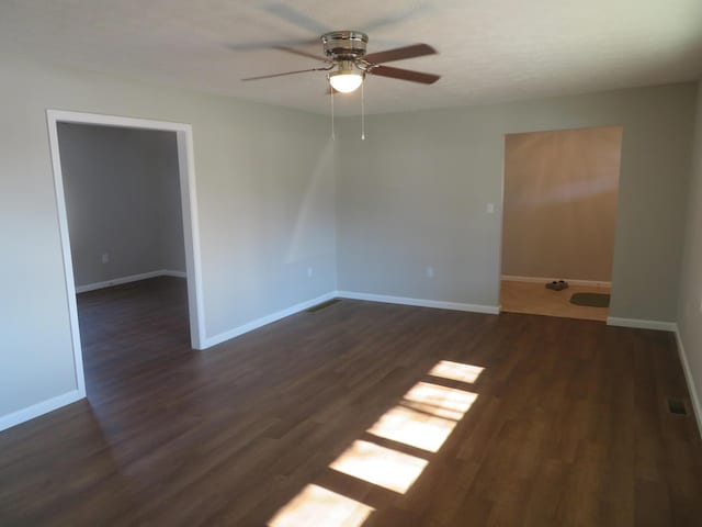 spare room with dark hardwood / wood-style floors and ceiling fan