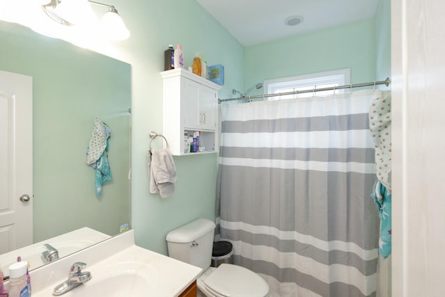 bathroom featuring vanity, curtained shower, and toilet