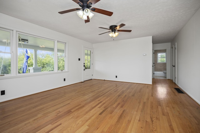 spare room featuring a textured ceiling and light wood-type flooring