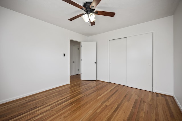 unfurnished bedroom with hardwood / wood-style floors, ceiling fan, and a closet