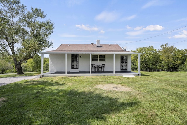 rear view of house with a porch and a lawn