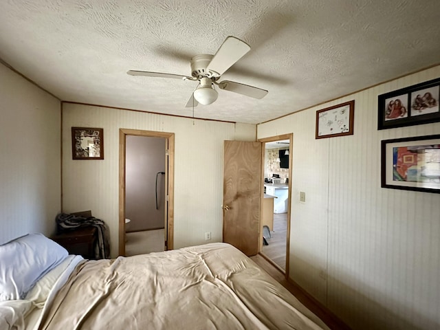 bedroom with ceiling fan and a textured ceiling