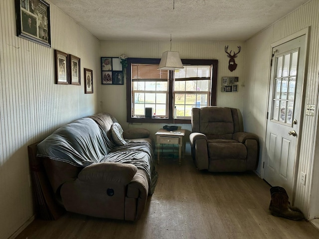 living area with hardwood / wood-style floors and a textured ceiling