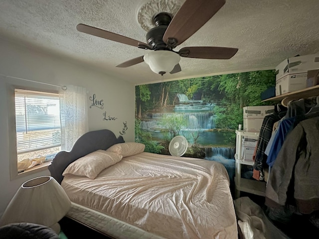 bedroom featuring ceiling fan and a textured ceiling