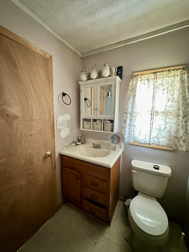 bathroom featuring vanity, a textured ceiling, and toilet