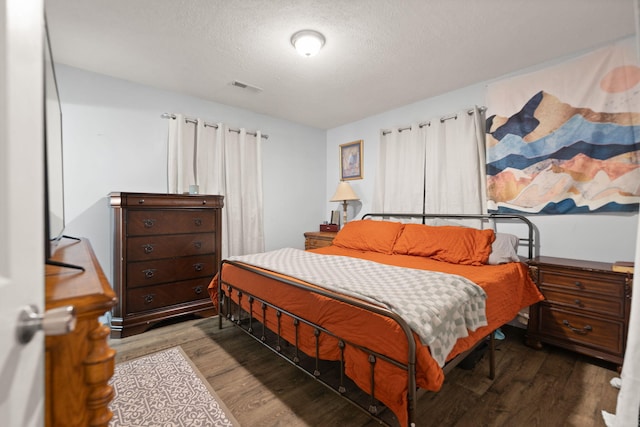 bedroom featuring wood-type flooring and a textured ceiling