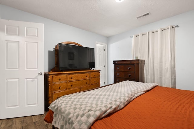 bedroom featuring dark hardwood / wood-style floors and a textured ceiling