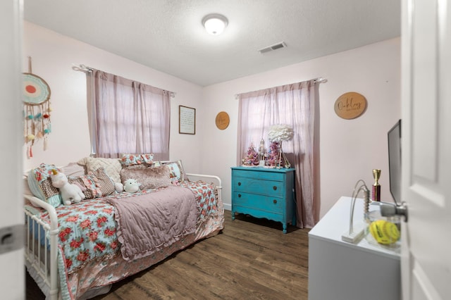 bedroom with dark wood-type flooring and a textured ceiling