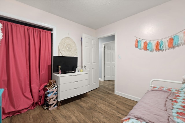 bedroom with dark hardwood / wood-style flooring