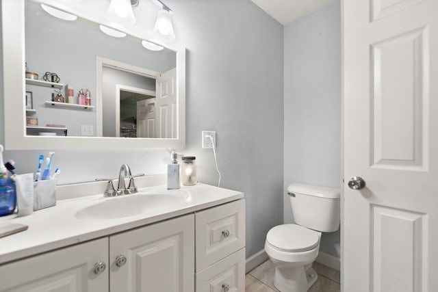 bathroom with vanity, tile patterned flooring, and toilet