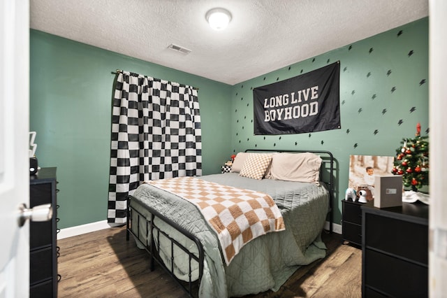 bedroom with hardwood / wood-style flooring and a textured ceiling