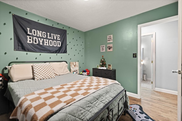 bedroom with hardwood / wood-style floors and a textured ceiling