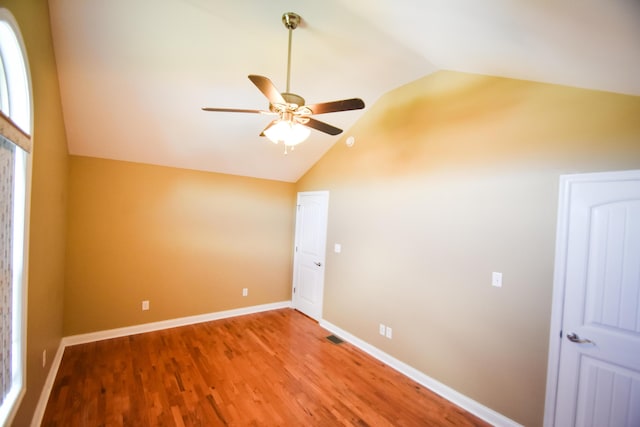 additional living space with vaulted ceiling, hardwood / wood-style floors, and ceiling fan