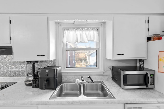 kitchen featuring sink, exhaust hood, and white cabinets