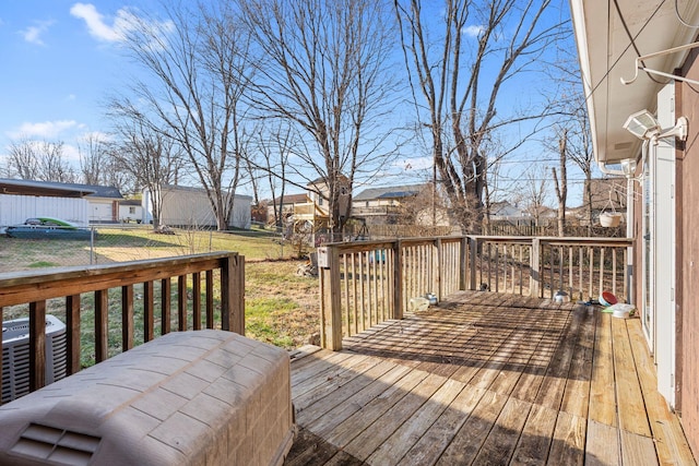 wooden deck with a lawn and central air condition unit